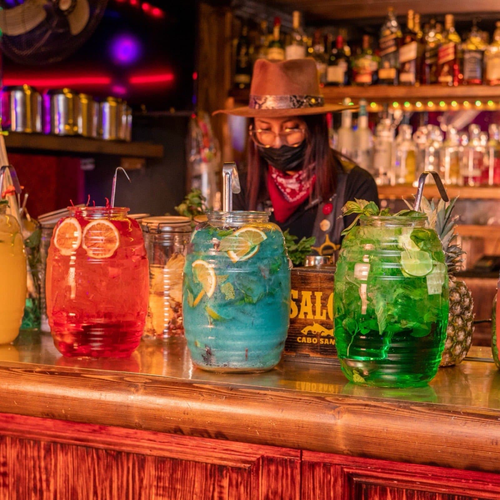 Giant colorful drink jars at Saloon Bar, a stop on the Cabo Party Access bar crawl